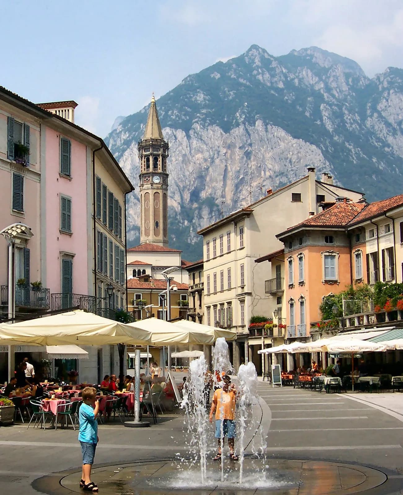terrasses de cafés sur une place de Lecco au pied du campanile et de la Grigna