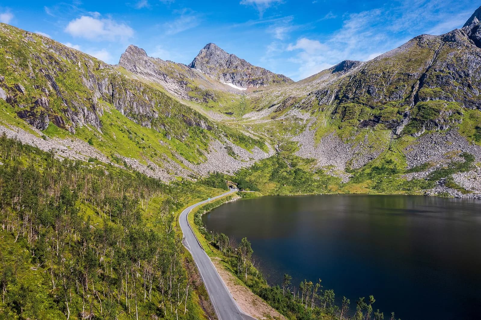 la route Fv862 serpente le long du lac Krokelvvatnet entre les montagnes verdoyantes de Senja