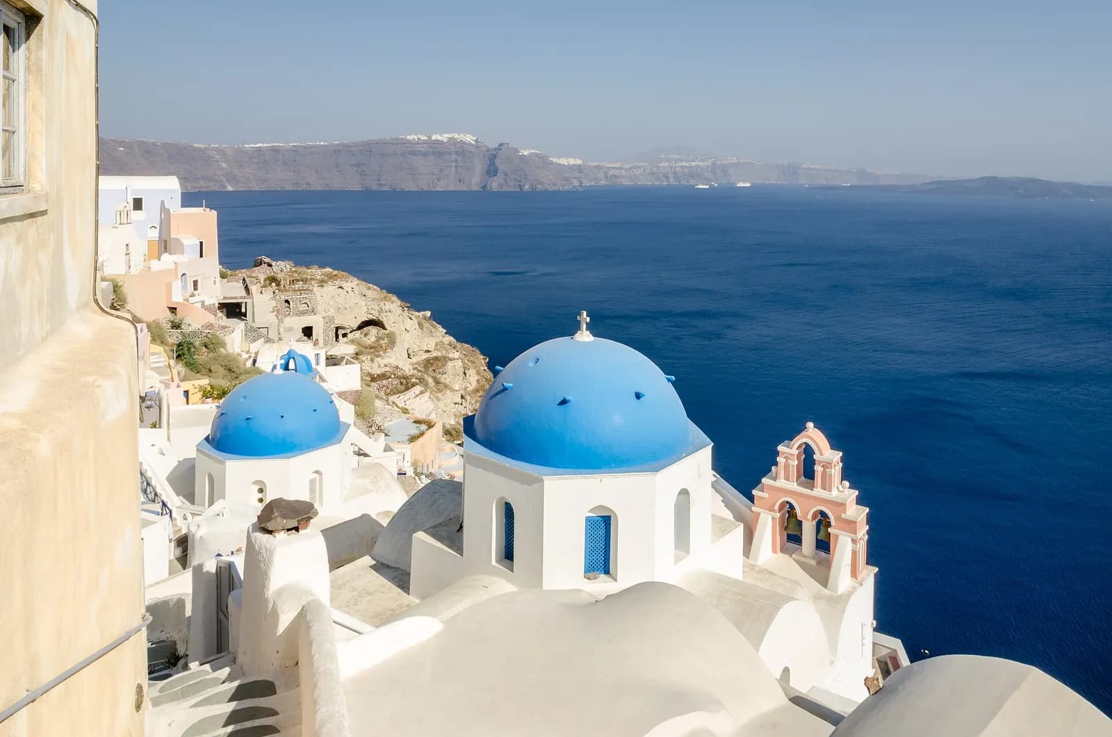 the blue church domes of Oia facing the Aegean Sea