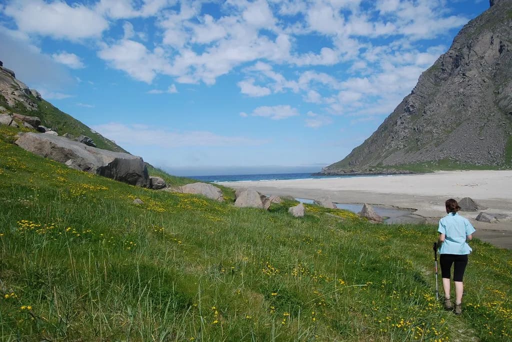 randonneuse sur le sentier herbeux descendant vers la longue plage sauvage de Horseid
