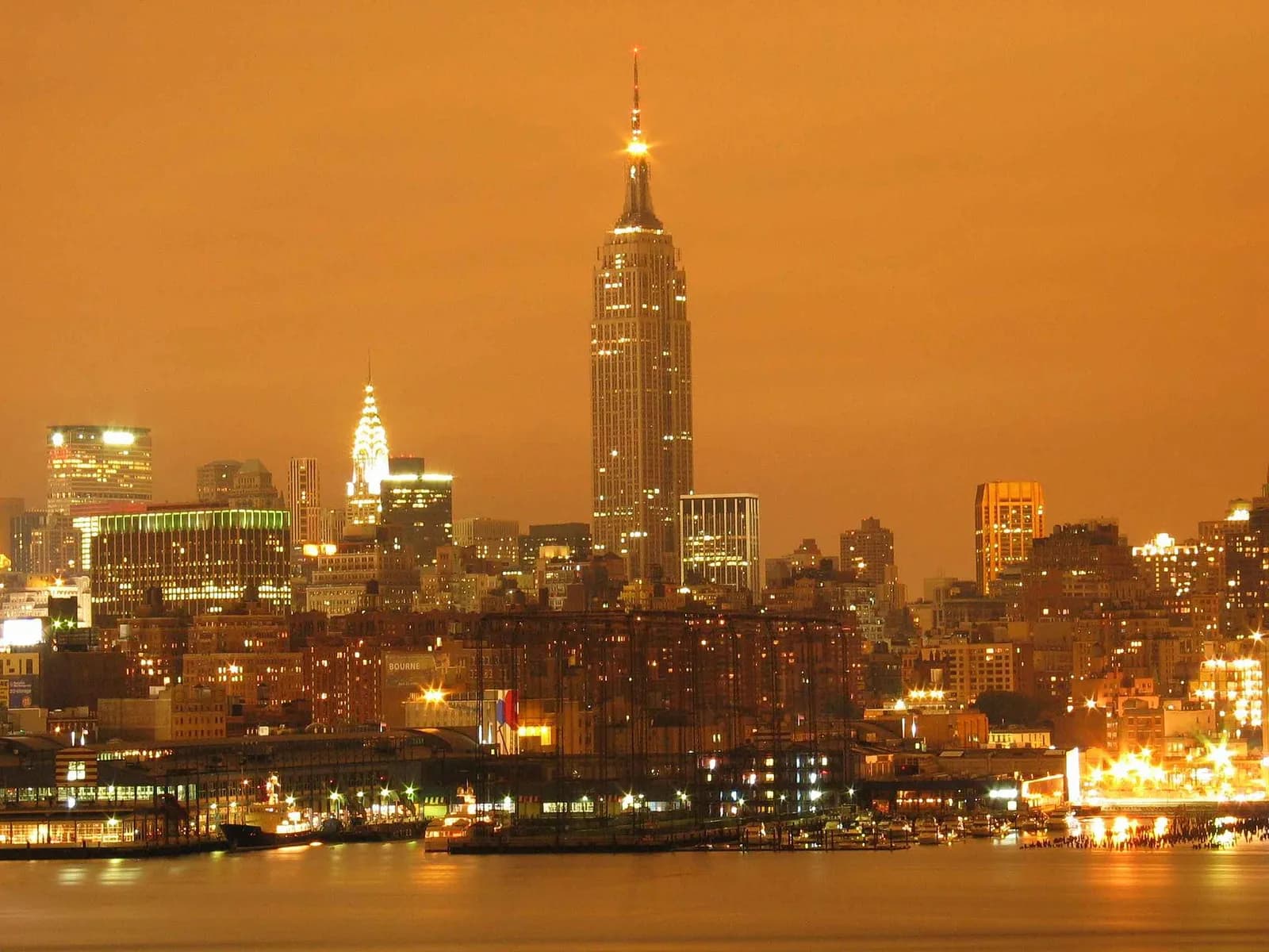 l'Empire State Building dominant la skyline nocturne de Midtown au-dessus de l'Hudson