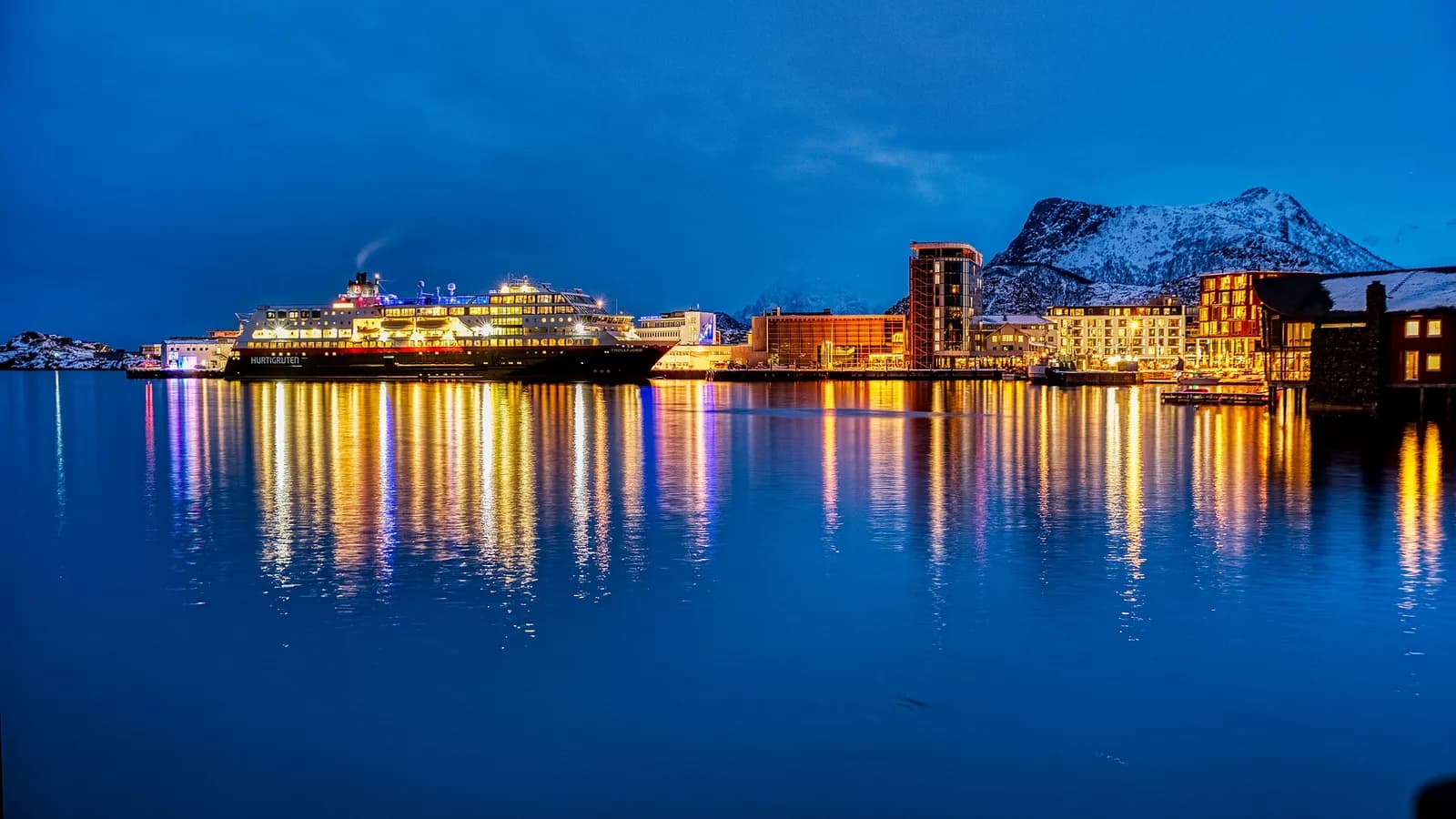 port de Svolvær illuminé à l'heure bleue avec un navire Hurtigruten à quai