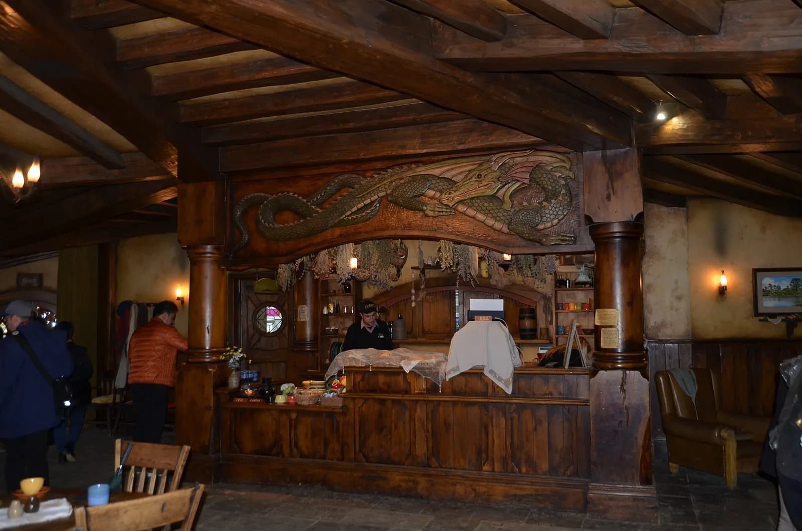 le comptoir en bois sculpté et l'intérieur chaleureux de l'auberge du Dragon Vert