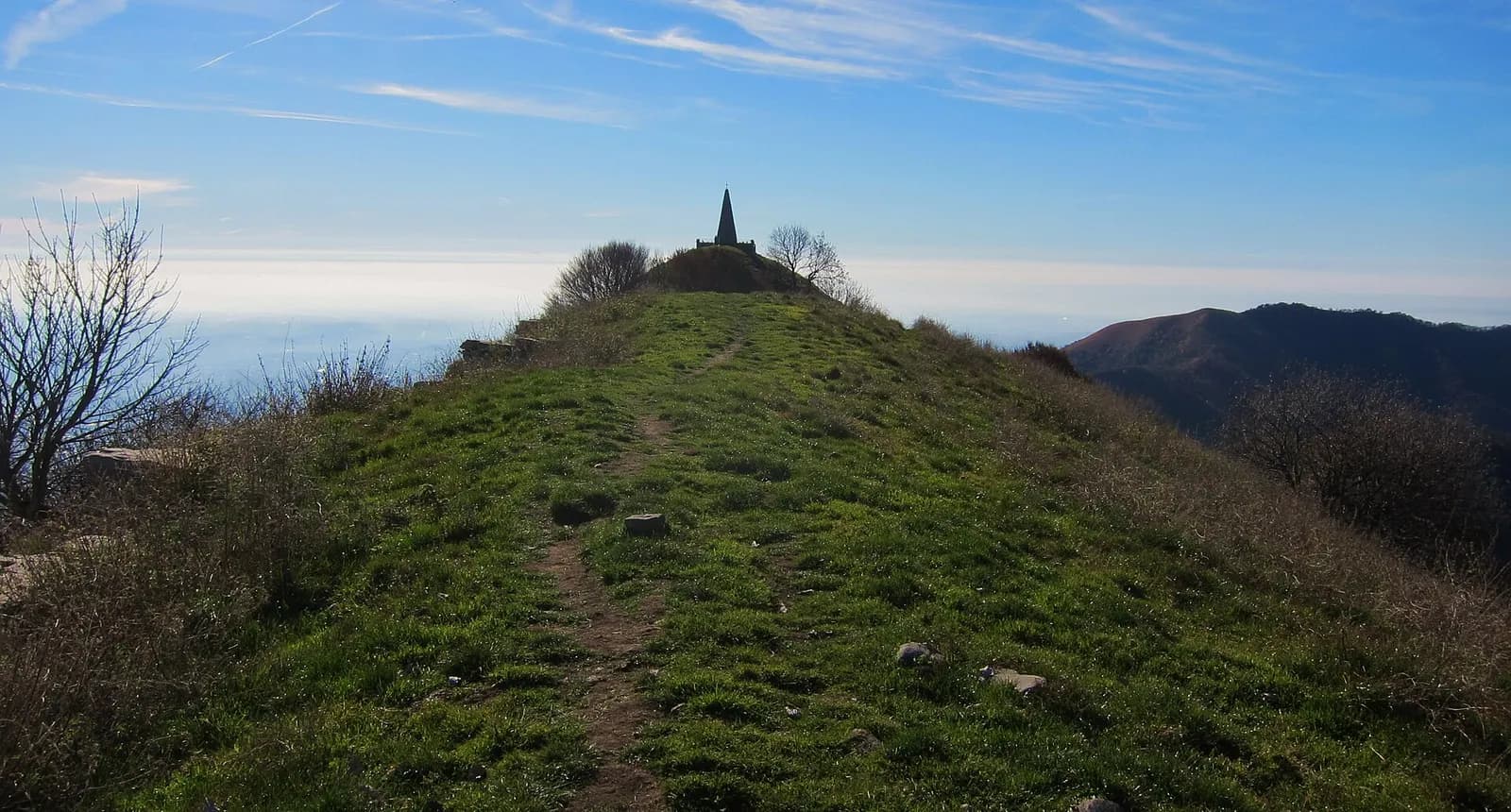 sentier herbeux menant à la chapelle pyramidale au sommet du Monte Palanzone