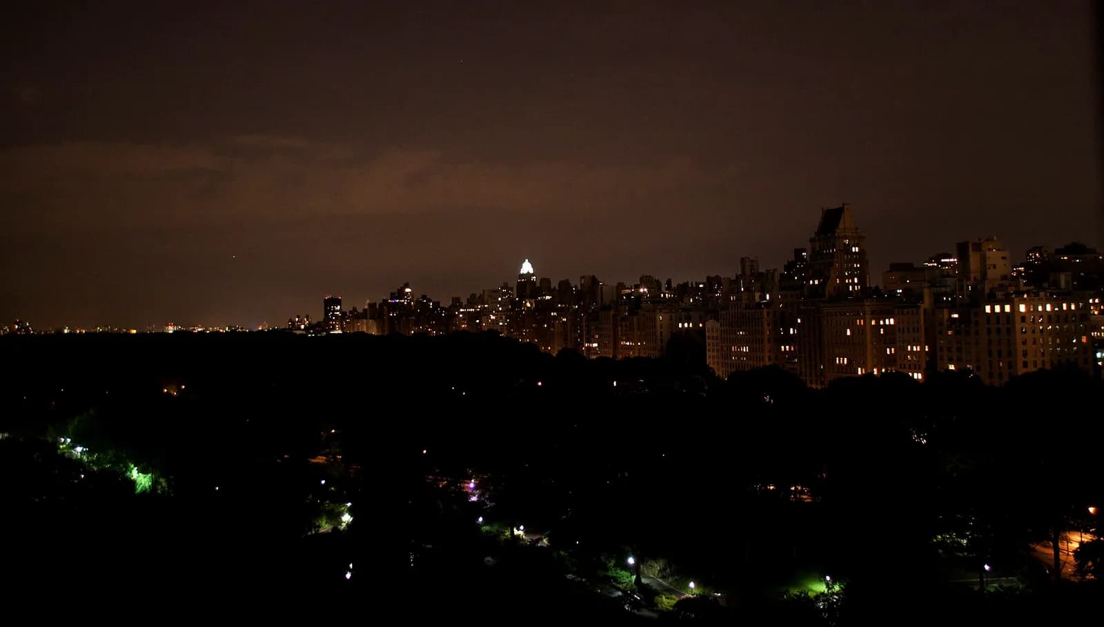 Central Park plongé dans la nuit, seulement éclairé par quelques lampadaires