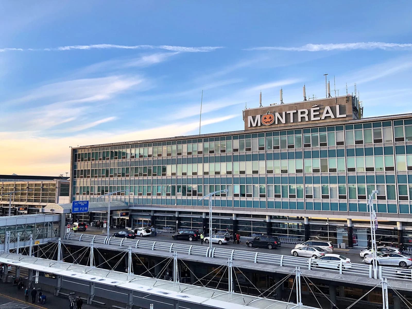 l'aérogare de l'aéroport Montréal-Trudeau et son enseigne Montréal sous un ciel bleu