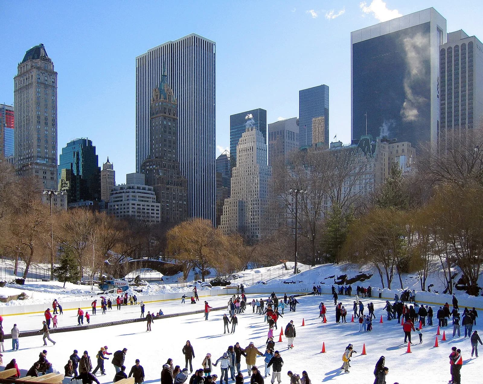 patineurs sur la glace de Wollman Rink en hiver, devant les gratte-ciels de Midtown