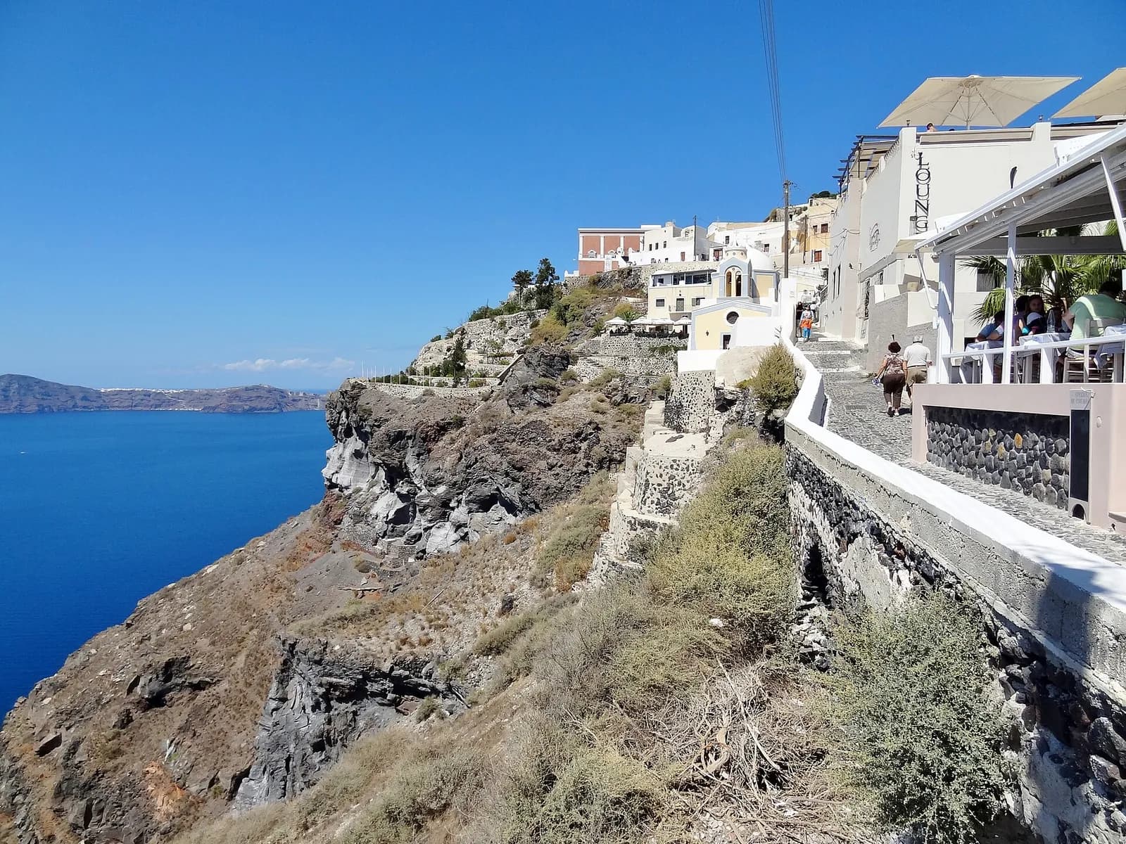 a clifftop path in Fira running along the edge of the caldera