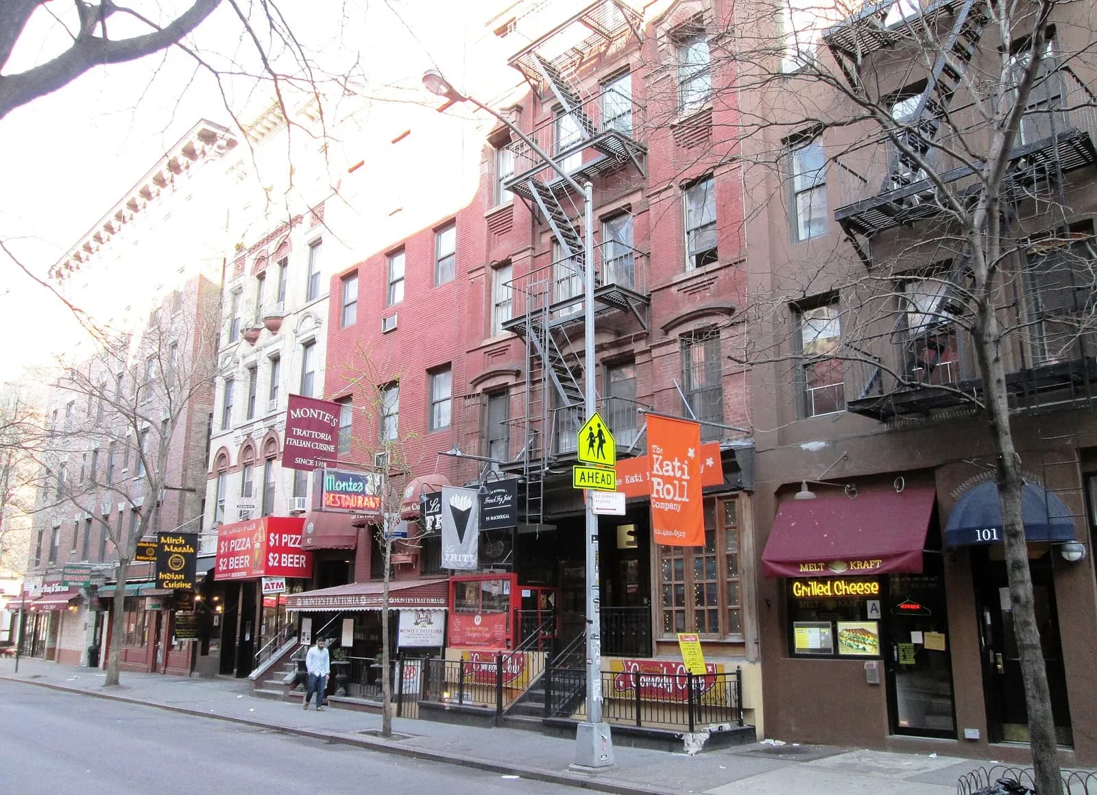 trottoir de MacDougal Street bordé d'immeubles à escaliers de secours et de boutiques
