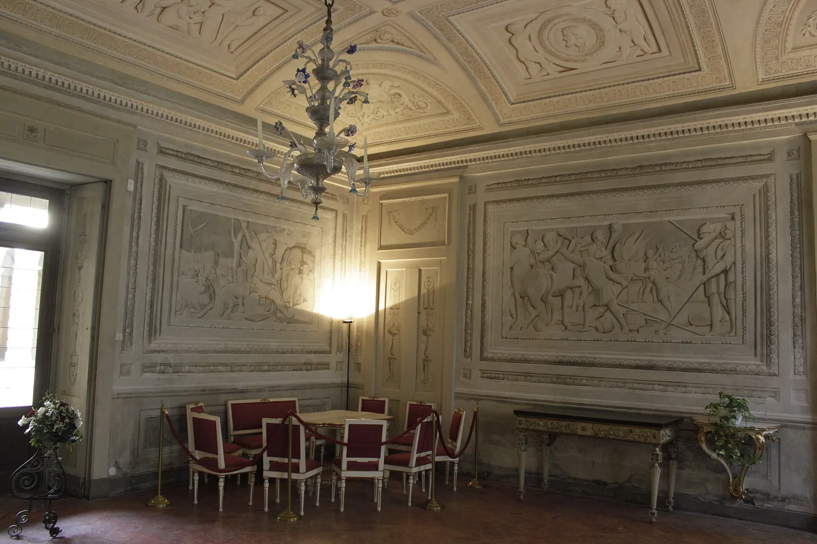 salon aux murs sculptés et lustre en verre à l'intérieur de la Villa Manzoni à Lecco