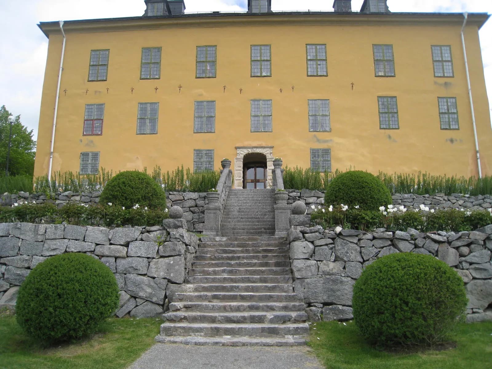 la façade sud jaune du château de Wenngarn et son escalier encadré de buis