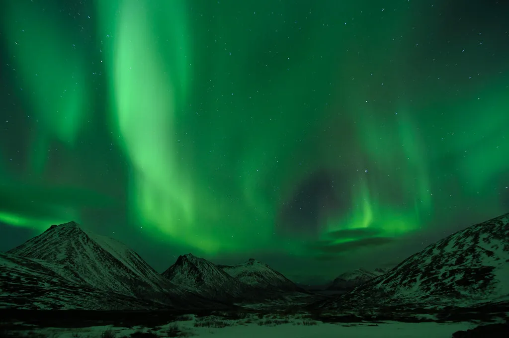 voiles d'aurore boréale au-dessus des sommets enneigés de l'île de Kvaløya en janvier