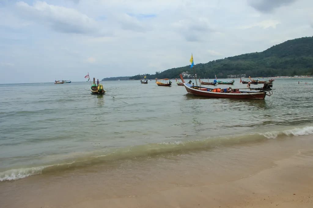 bateaux longtail colorés ancrés près du rivage de Kamala Beach