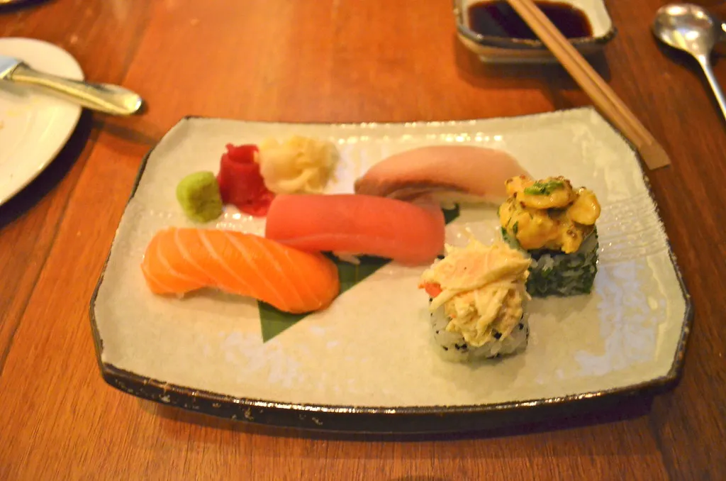 a plate of salmon and tuna nigiri with ginger and wasabi
