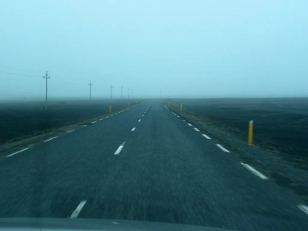la route 1 islandaise filant à travers une plaine de cendres noyée dans la brume