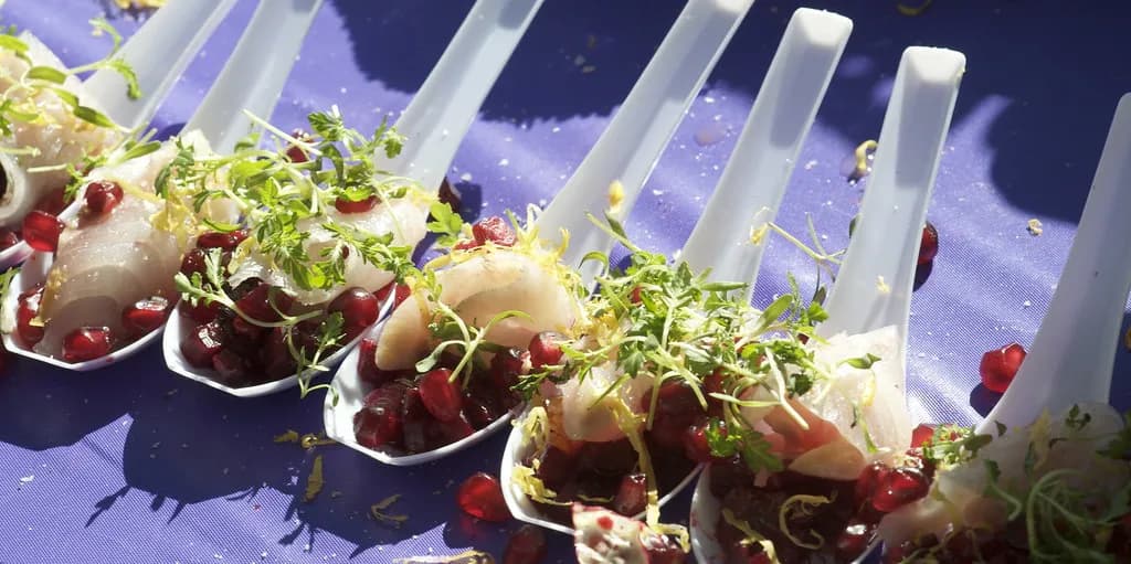 gourmet bites served in porcelain tasting spoons at a fine-dining table