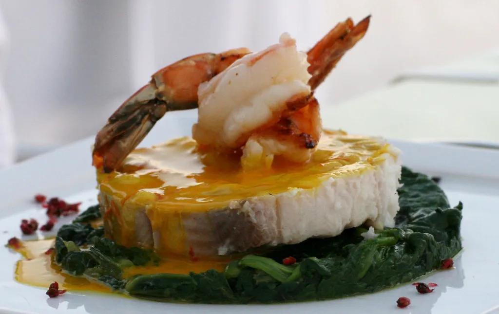 fish with saffron sauce and prawn on a bed of spinach, served in Fira