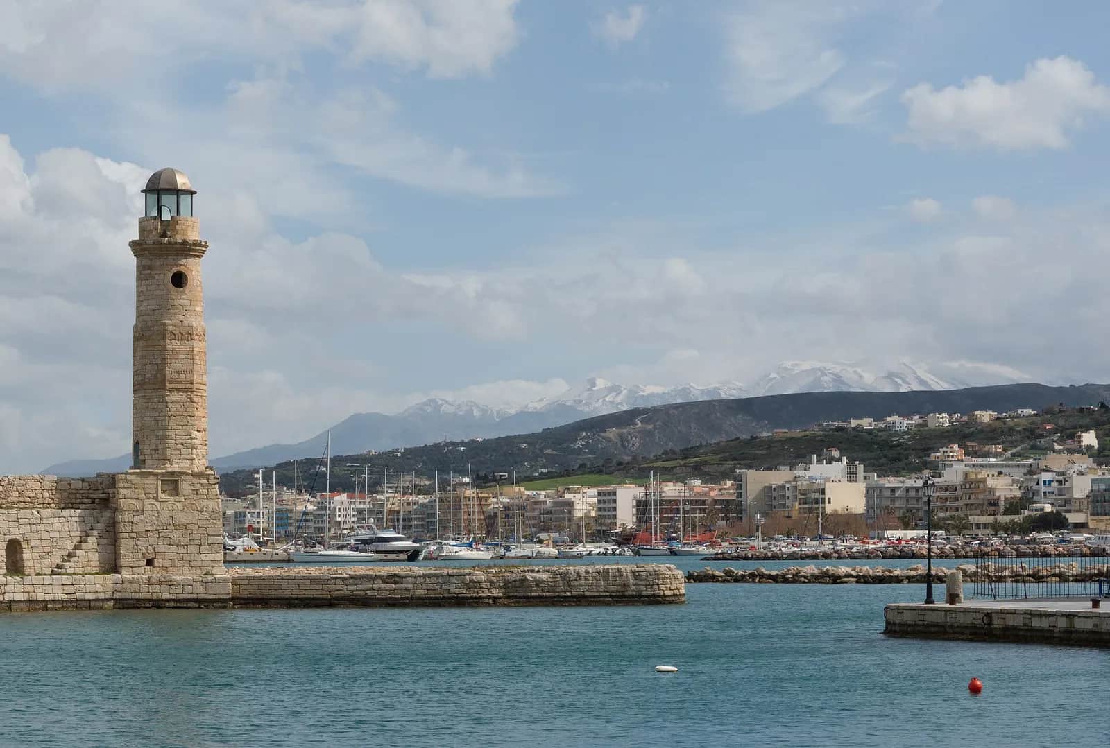 Phare vénitien du port de Réthymnon avec les montagnes enneigées de l'intérieur en arrière-plan