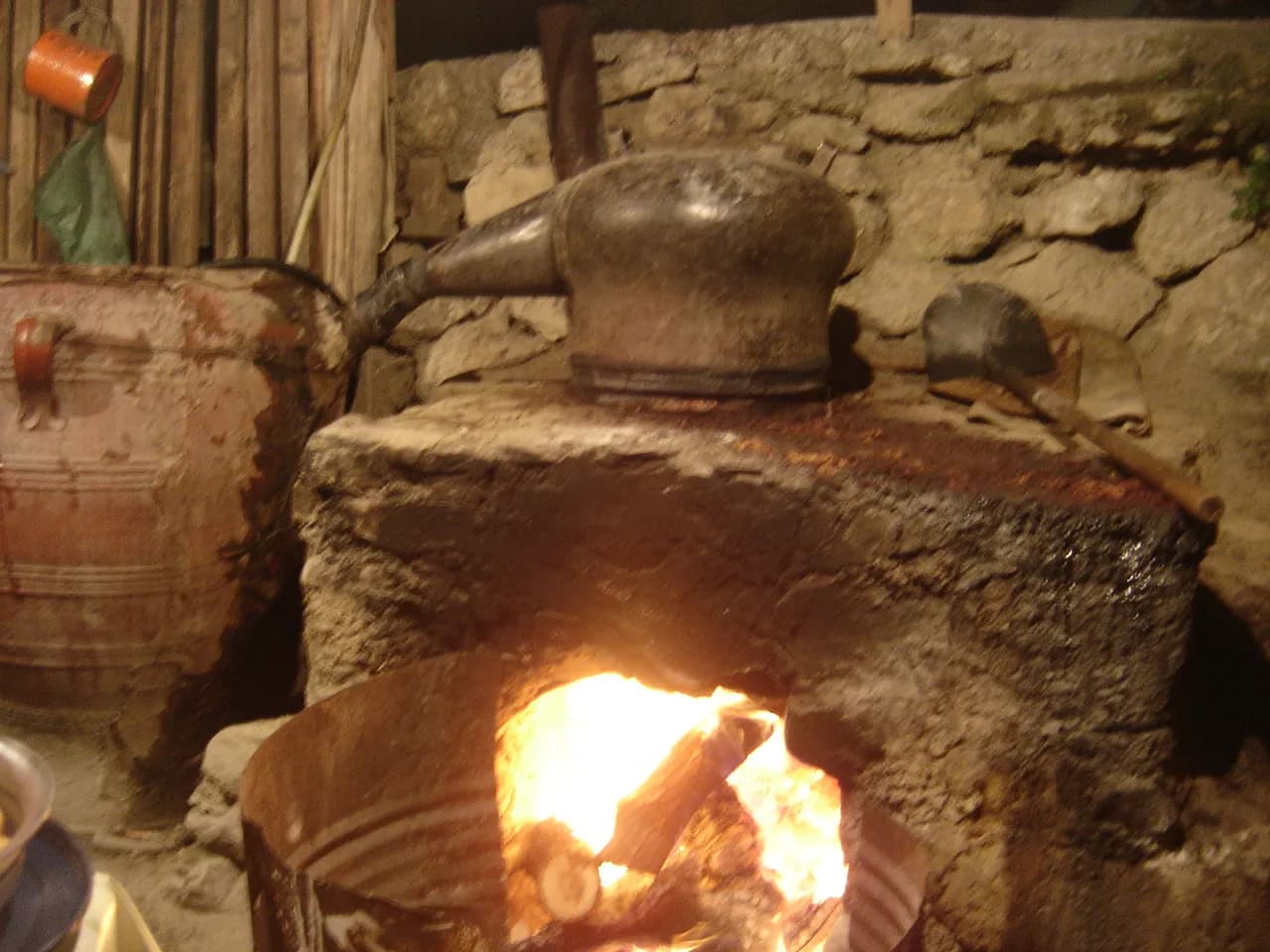 Alambic traditionnel en cuivre chauffé au feu de bois pour distiller le raki à Amira, en Crète