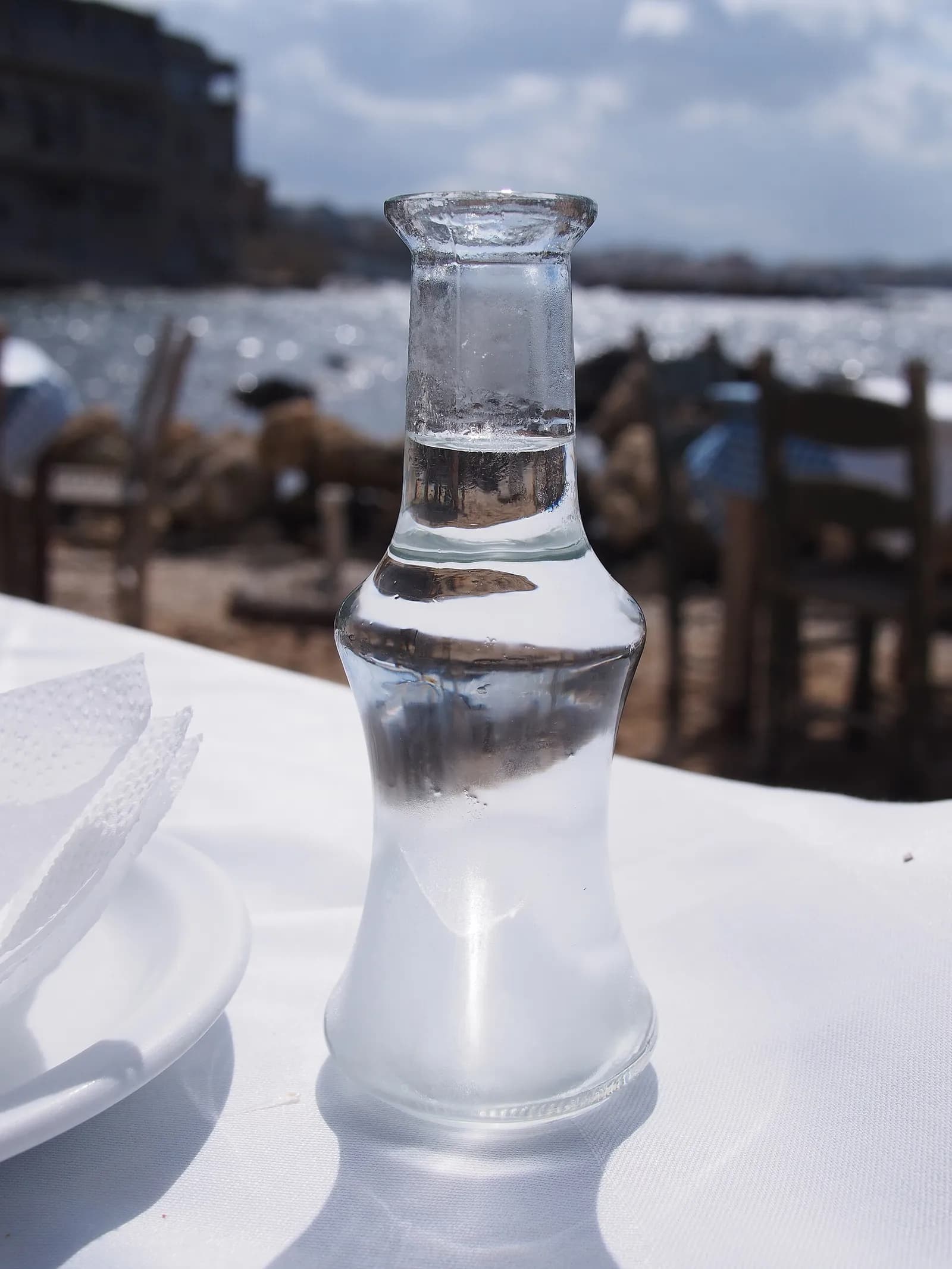 Carafe de tsikoudia fait maison servie sur une table de restaurant au bord de l'eau à La Canée