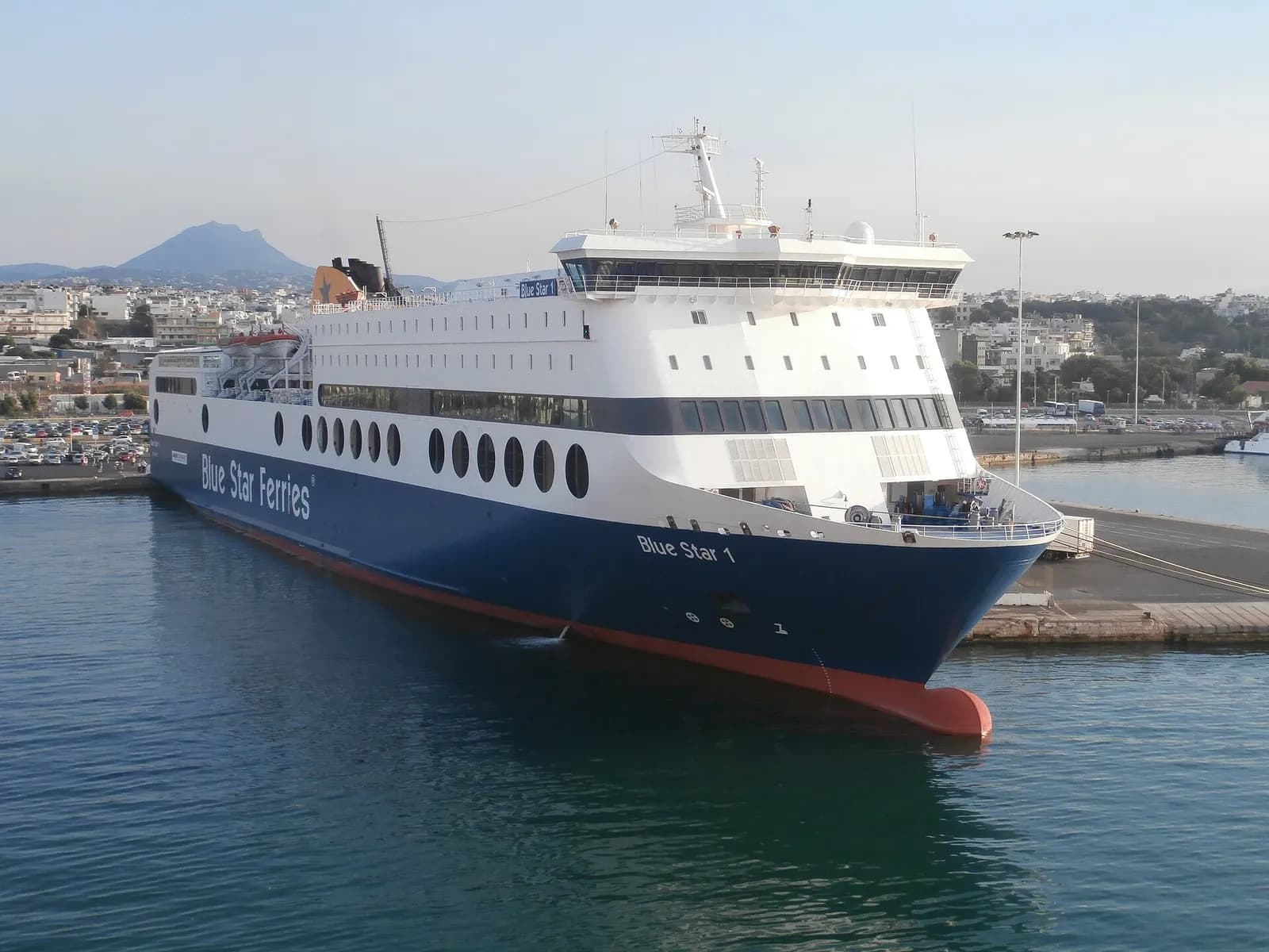 Un ferry Blue Star Ferries à quai dans le port d'Héraklion, avec la ville et les montagnes en arrière-plan