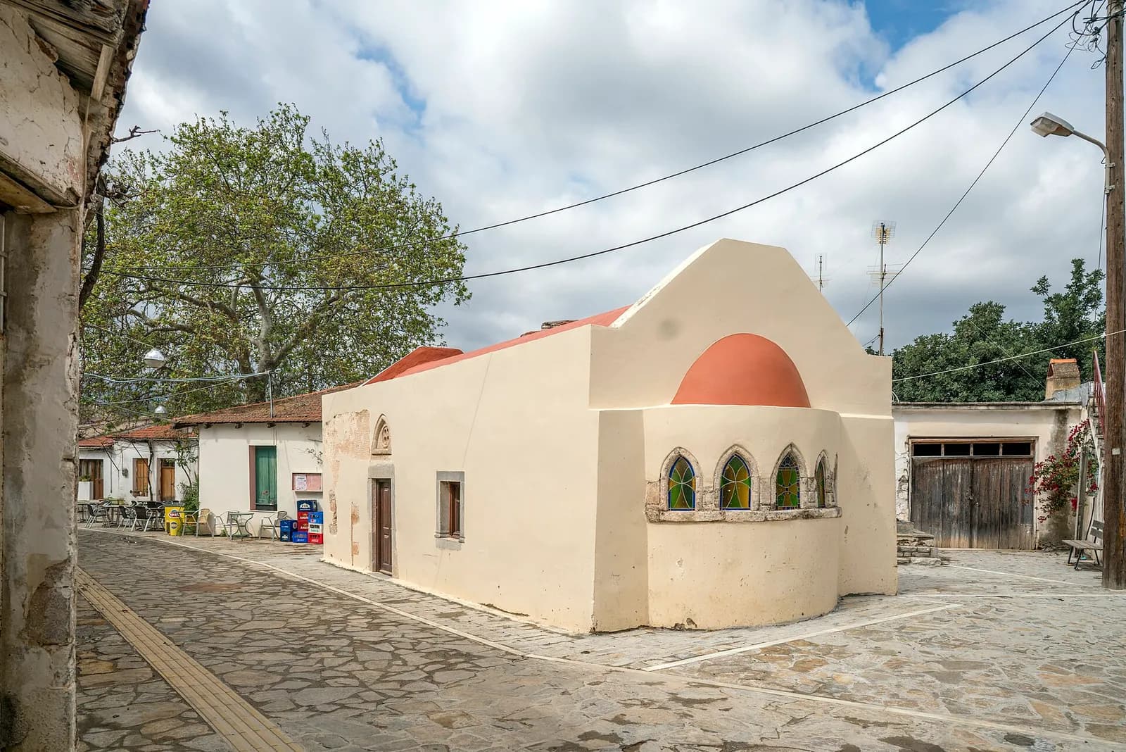 La petite église Sainte-Anne de Fourni, avec son abside à coupole rouge et ses vitraux, sur la place