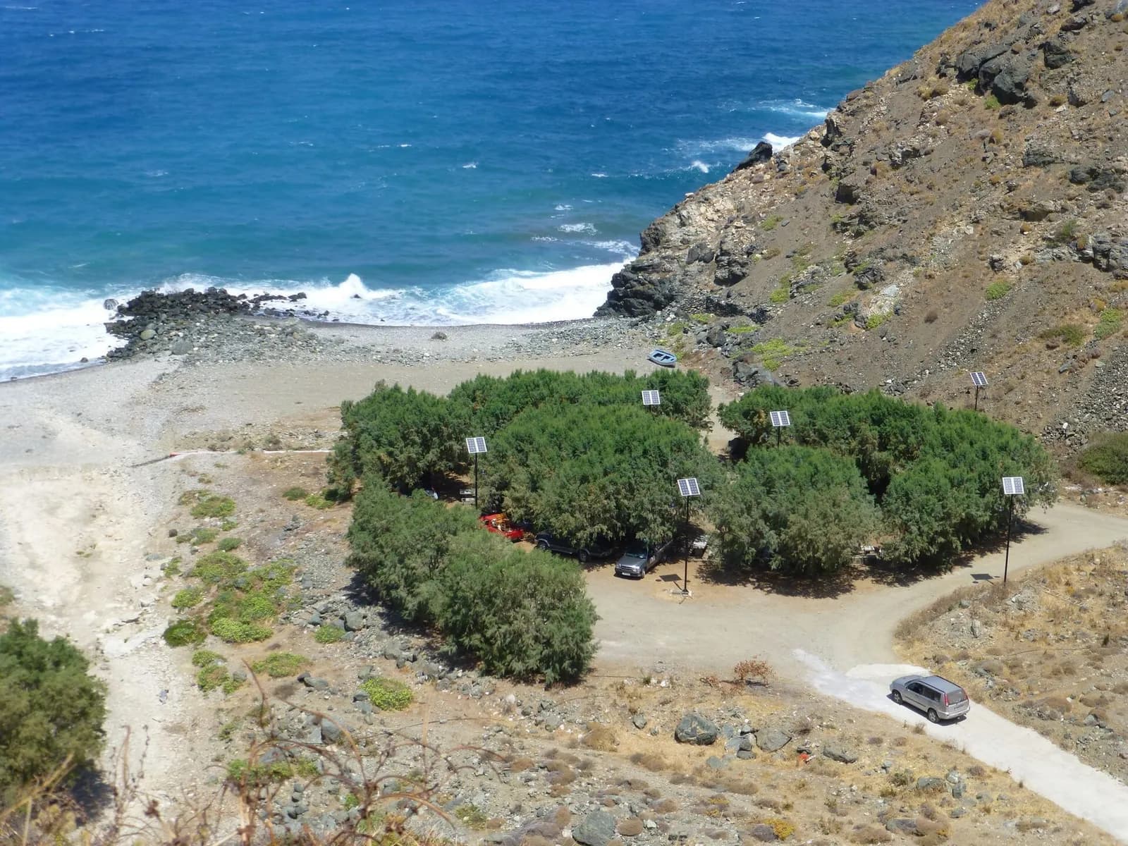 La petite plage de galets de Richtis et ses tamaris au débouché des gorges, vue depuis la route