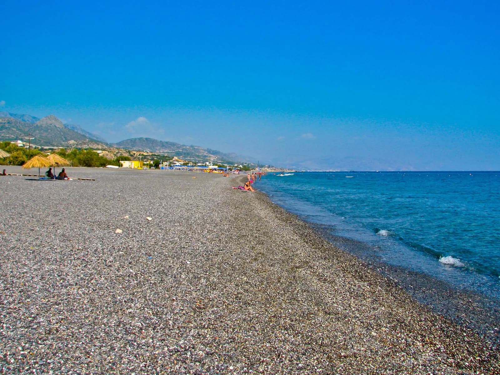 La longue plage de galets de Koutsounari qui file vers l'est, montagnes en arrière plan
