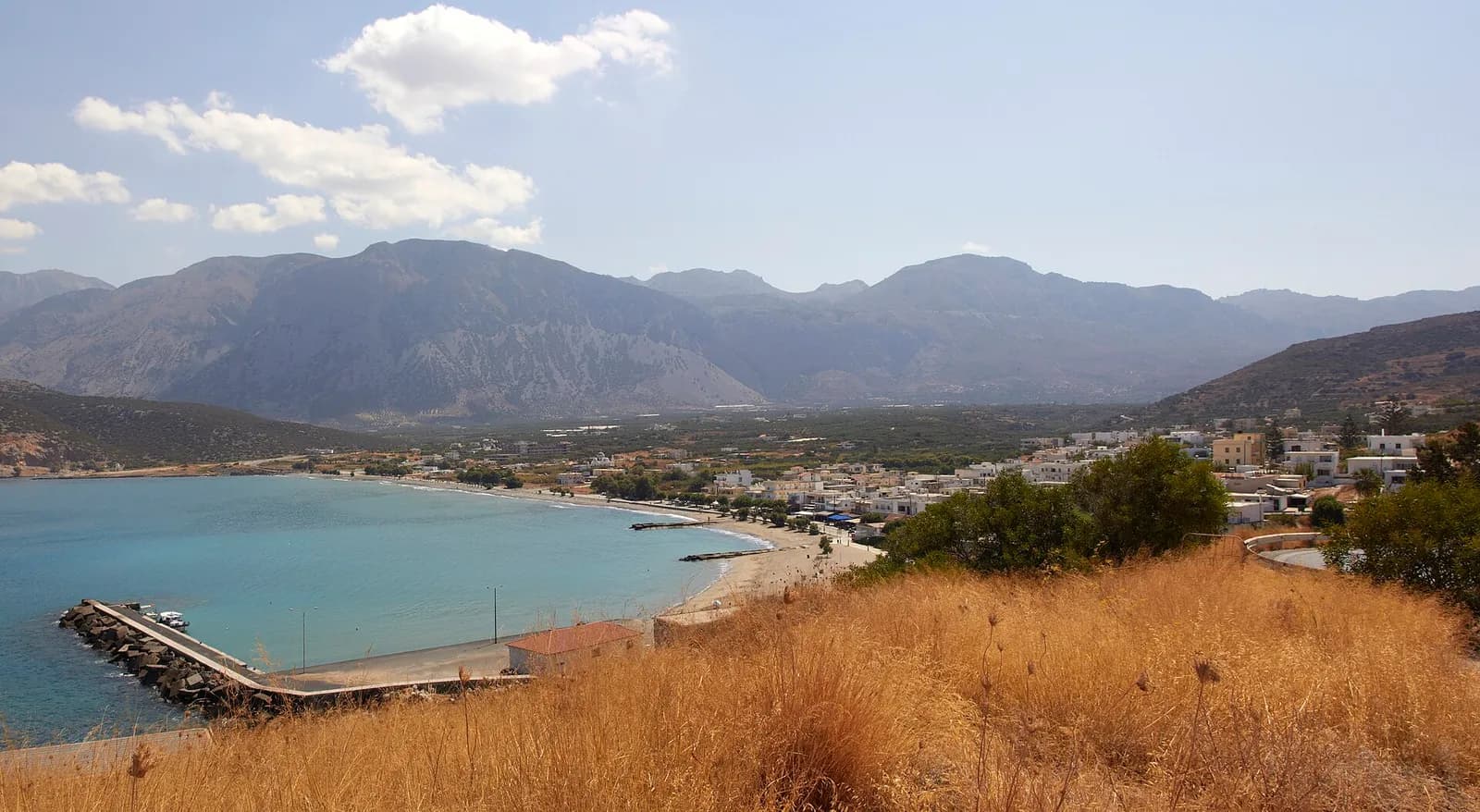 La baie de Pacheia Ammos, sa jetée et sa plage au fond du golfe de Mirabello, au pied des montagnes