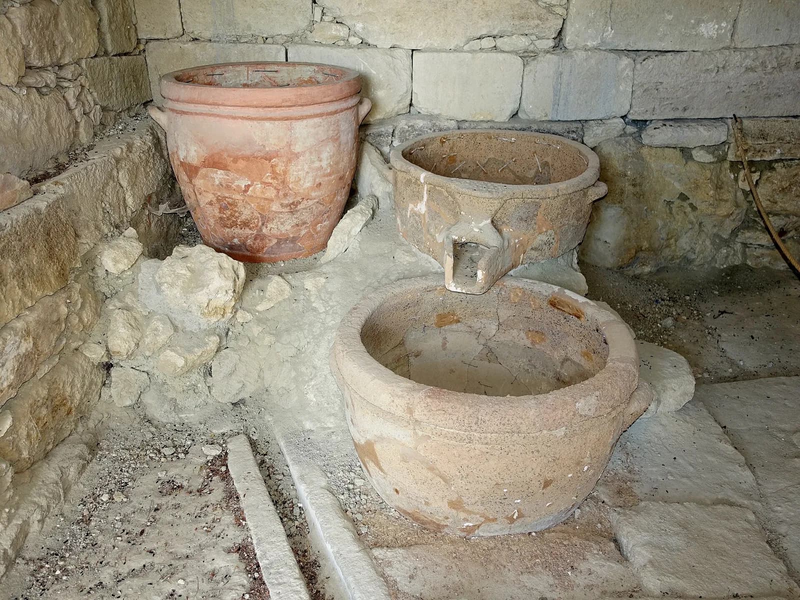 Le pressoir minoen de la villa de Vathypetro, avec sa cuve à bec verseur et ses jarres en terre cuite