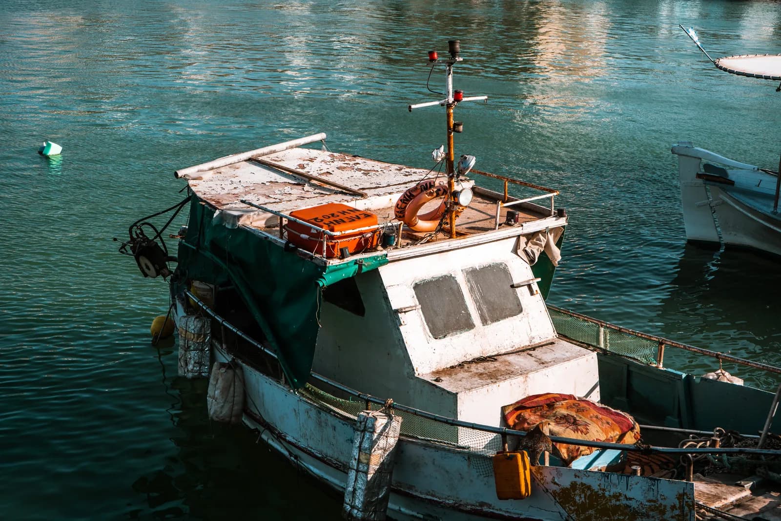 Vieux bateau de pêche en bois amarré dans l'eau verte du port vénitien d'Héraklion