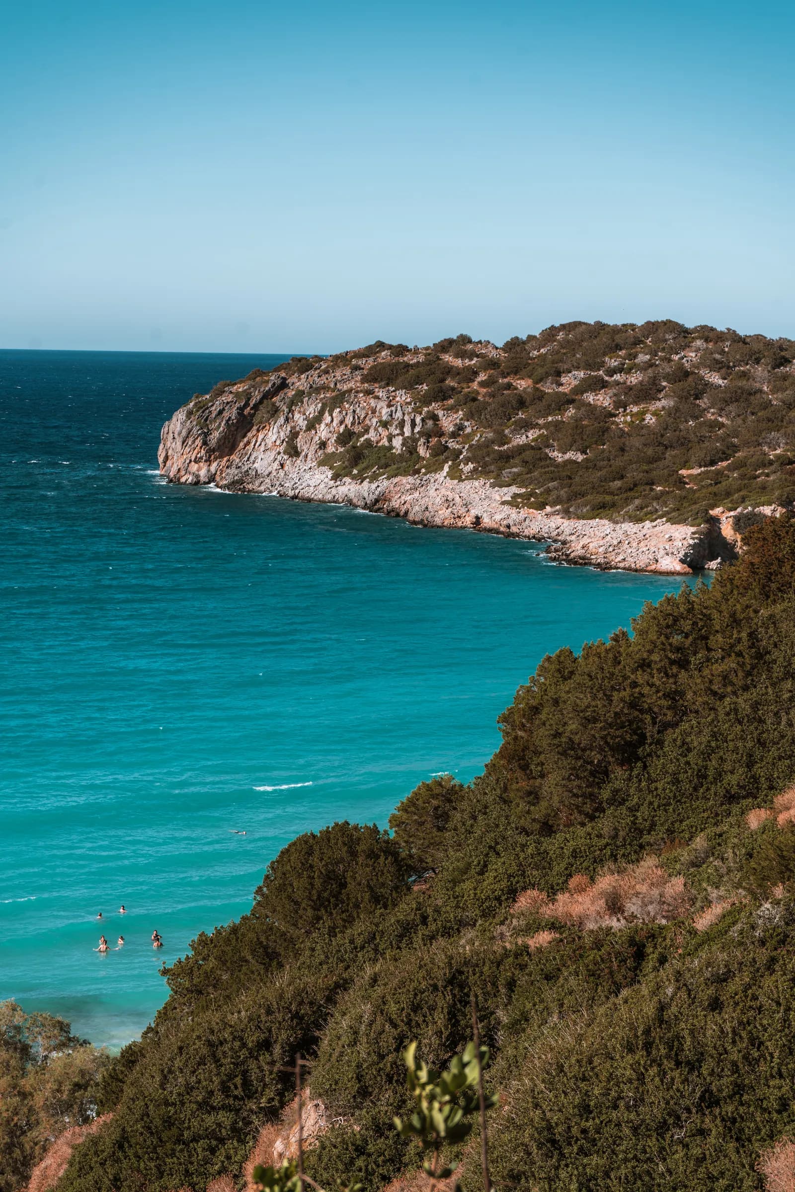 Cap rocheux couvert de garrigue plongeant dans une mer bleu turquoise près d'Istro