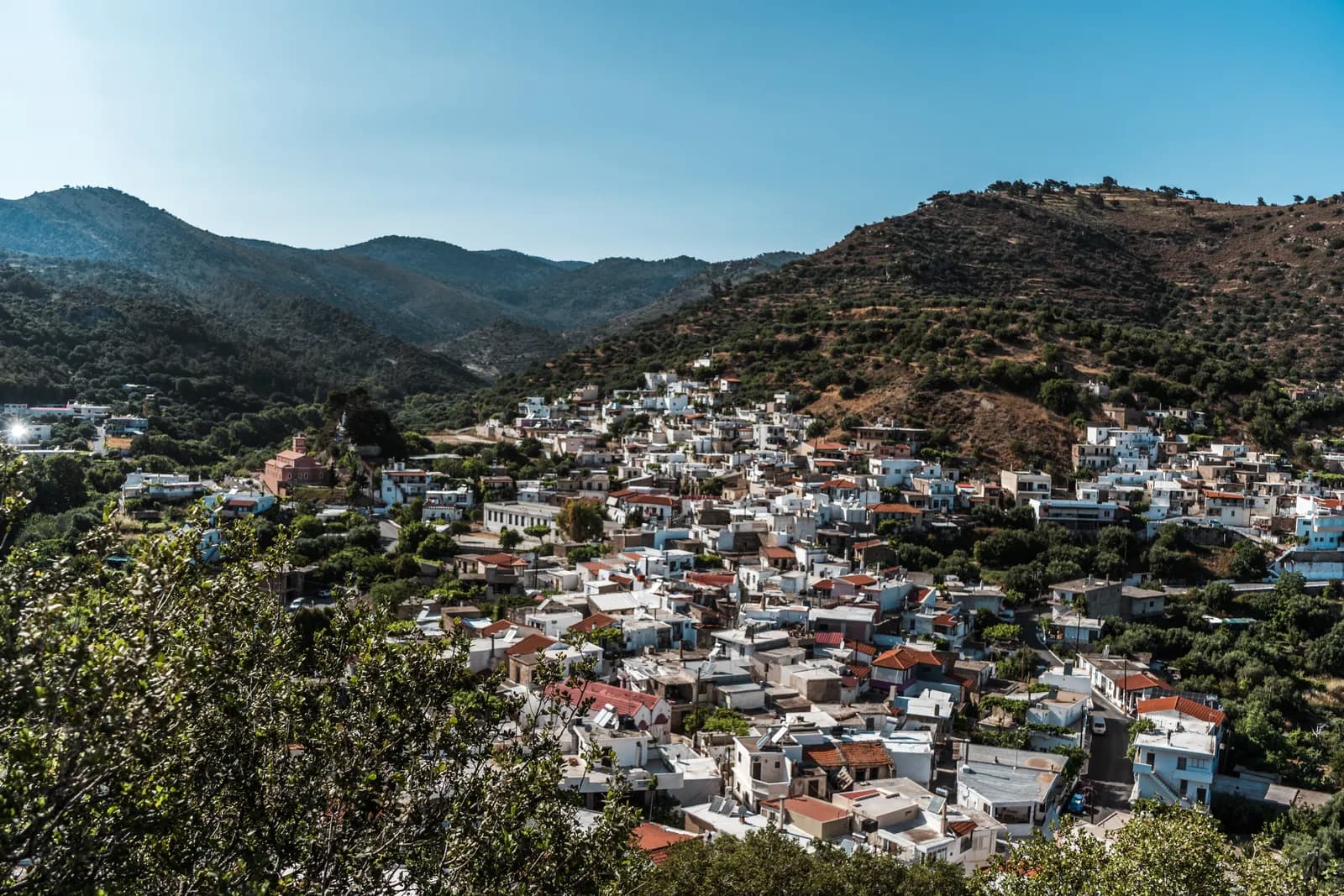 Cretan village of white houses nestled in a green valley surrounded by hills