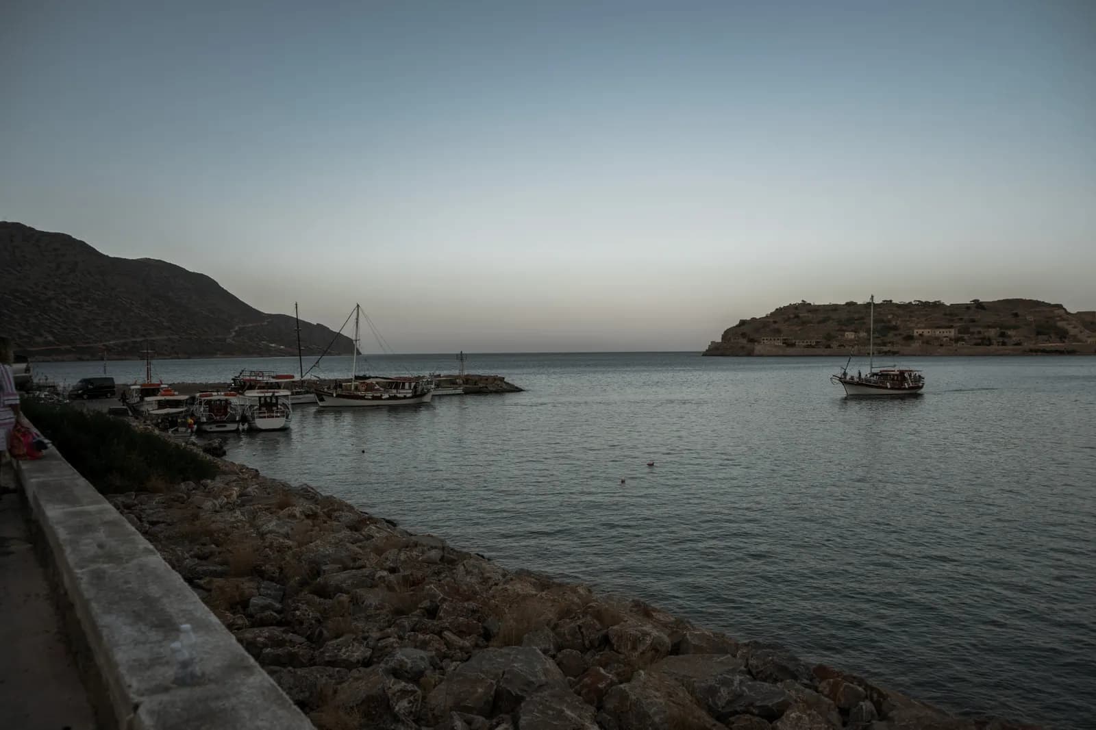 The little harbour of Plaka at dusk, caiques at anchor facing the fortified island of Spinalonga