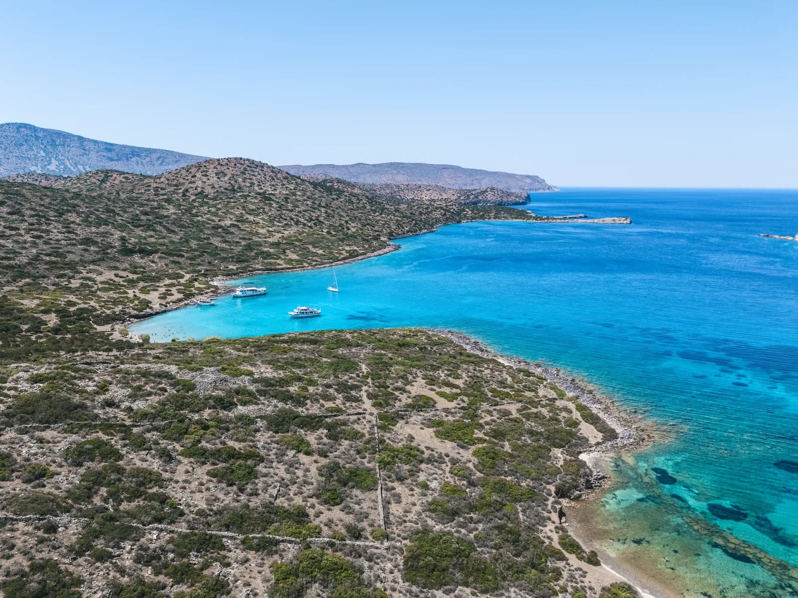 Baie turquoise et voiliers au mouillage autour de l'îlot de Kalydon, près d'Elounda en Crète