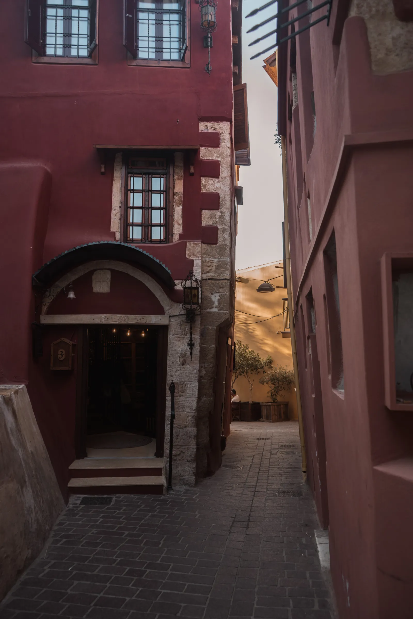 Ruelle pavée et façades vénitiennes rouges dans la vieille ville de La Canée, en Crète