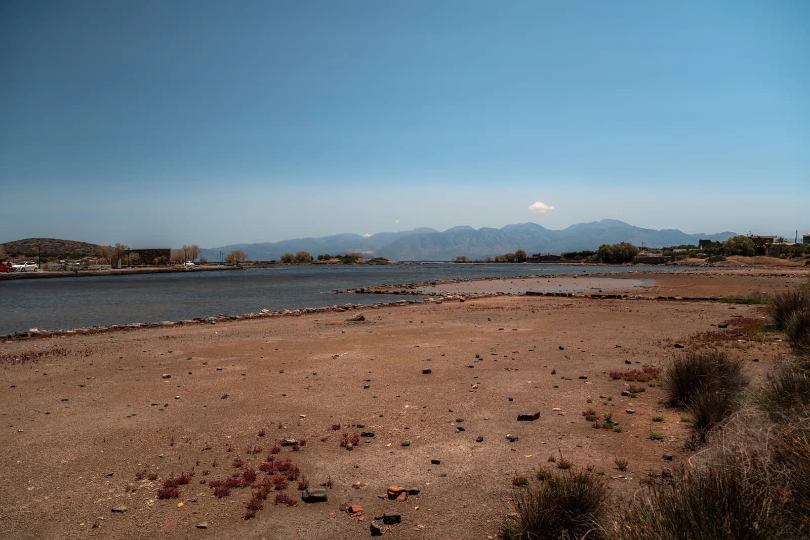 Bassins à sec des anciens marais salants près de la chaussée d'Elounda, face aux montagnes du golfe