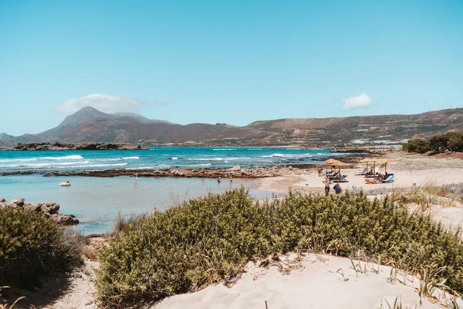 Dunes covered in vegetation and turquoise water north of Falassarna, facing the mountains