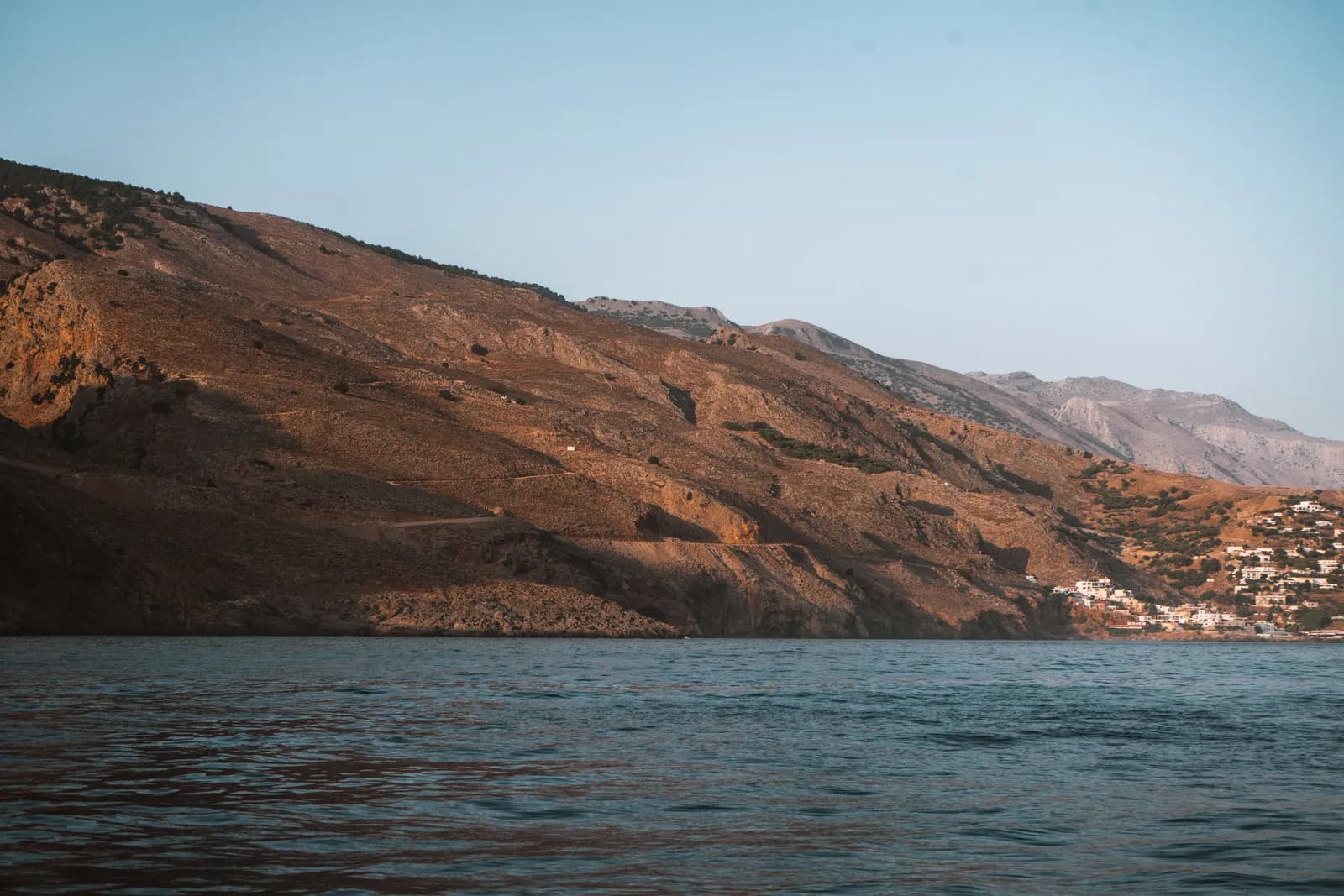 Montagnes dorées de la côte sud de la Crète vues depuis le pont d'un bateau, sur une mer calme