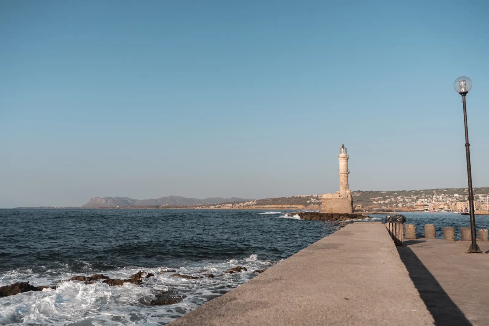 La jetée et le phare vénitien du port de La Canée, avec les vagues qui se brisent sur les rochers