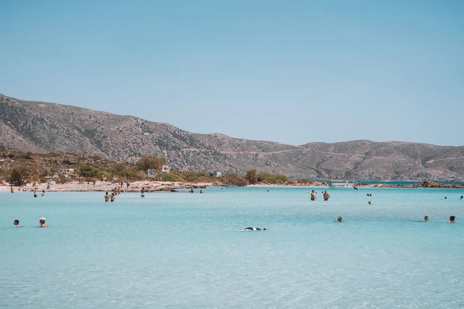 Le lagon peu profond d'Elafonisi, eau turquoise et sable clair, avec les collines du sud-ouest en fond