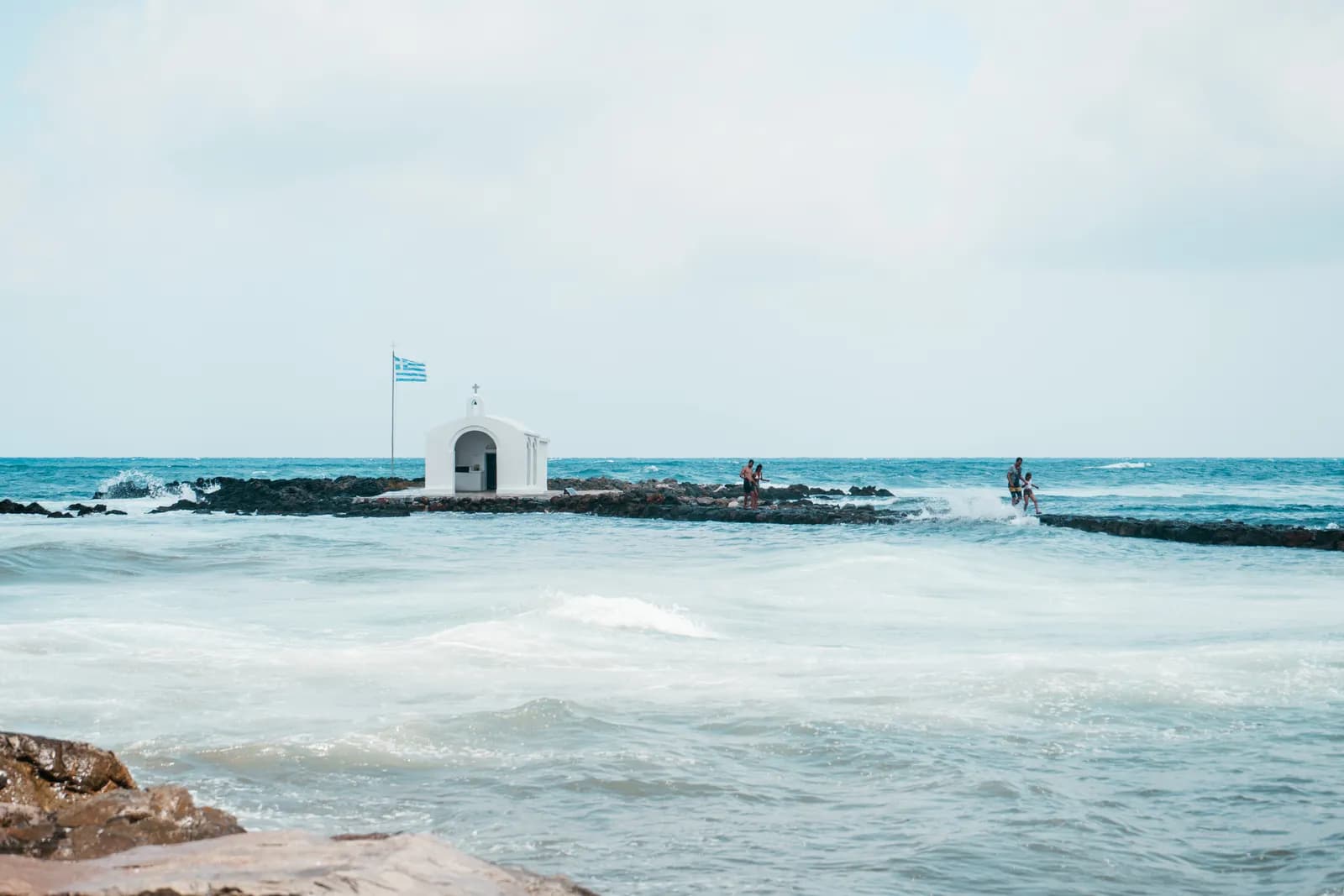 Chapelle blanche d'Agios Nikolaos au bout de sa jetée dans la mer à Georgioupolis
