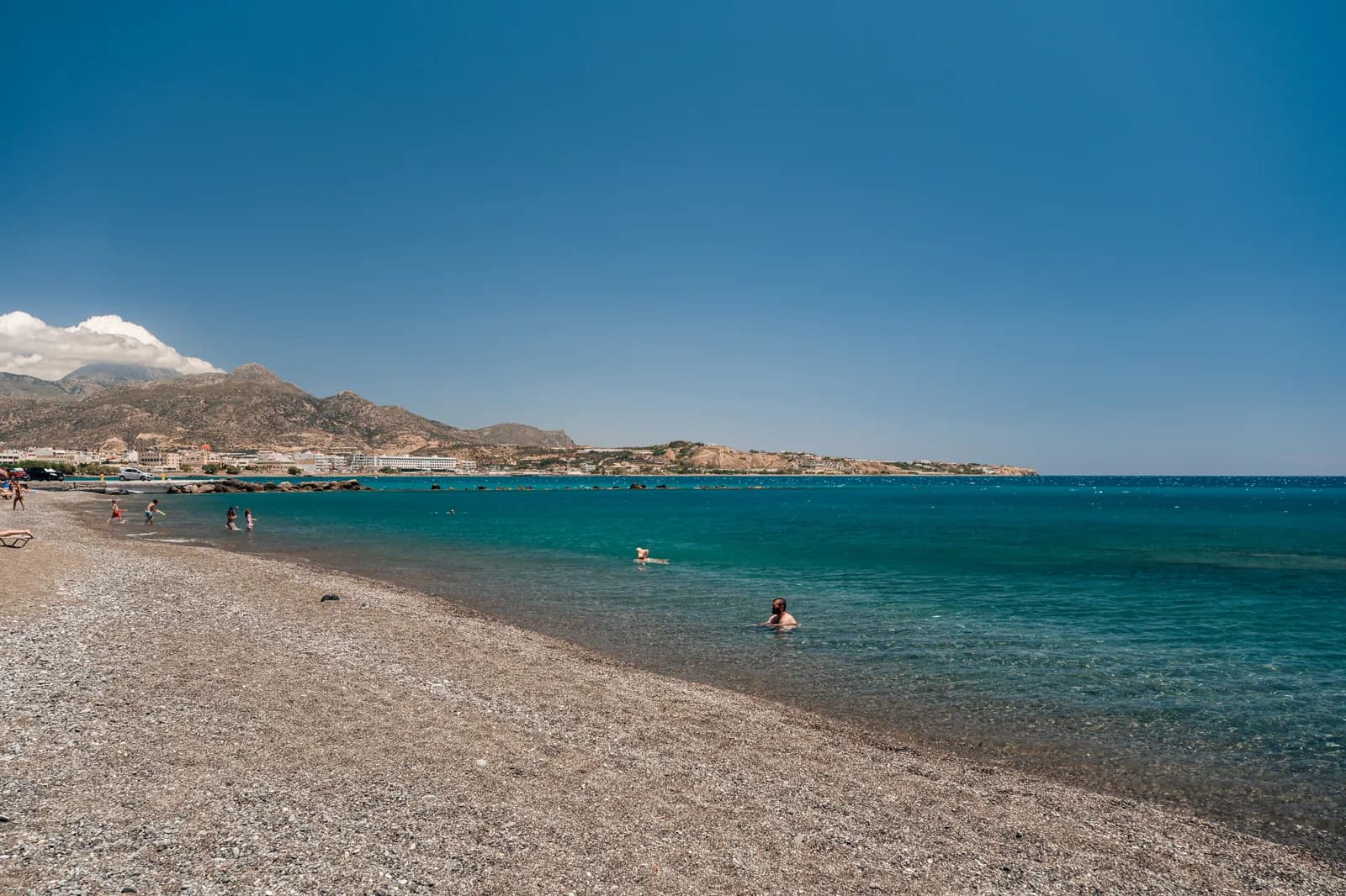 La longue plage de galets d'Ierapetra qui file vers l'est, eau turquoise et montagnes à l'horizon