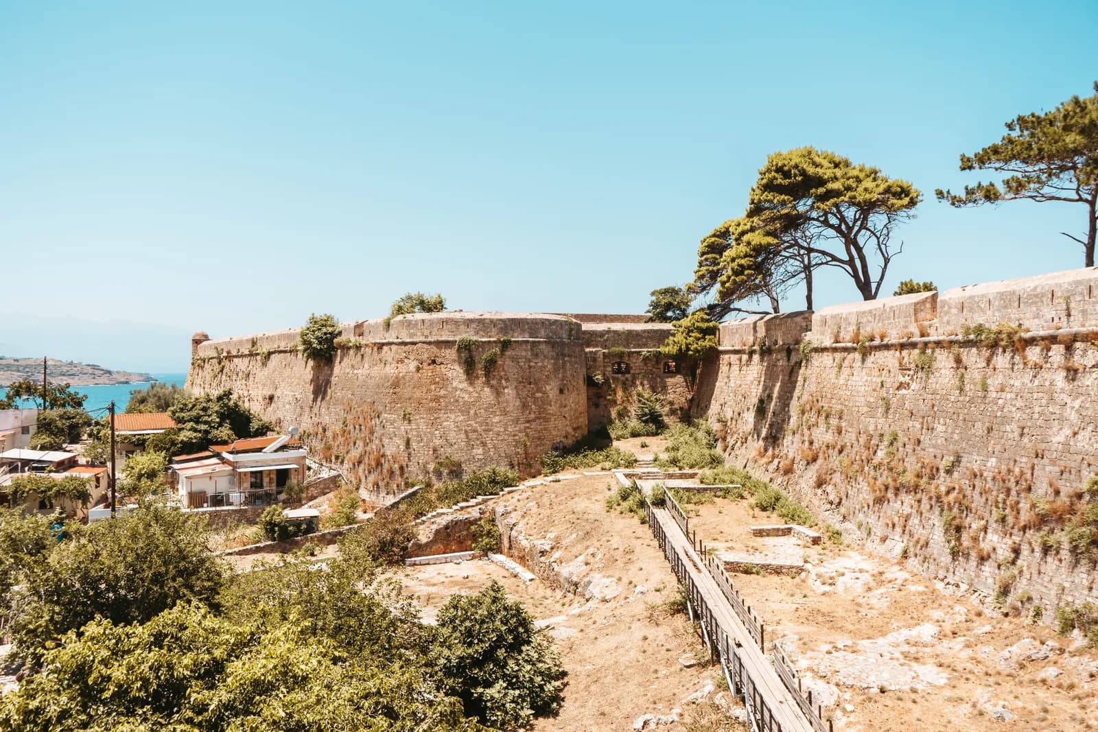 Les remparts massifs de la Fortezza de Réthymnon, bordés de pins, au-dessus de la vieille ville