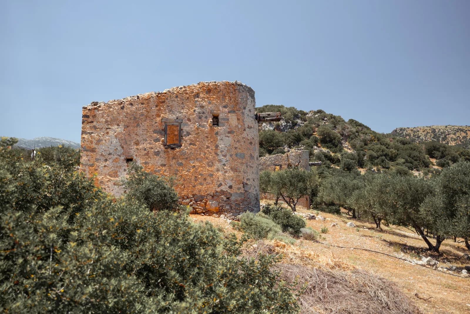 Ancien moulin de pierre en ruine parmi les oliviers, dans la campagne autour de Lato