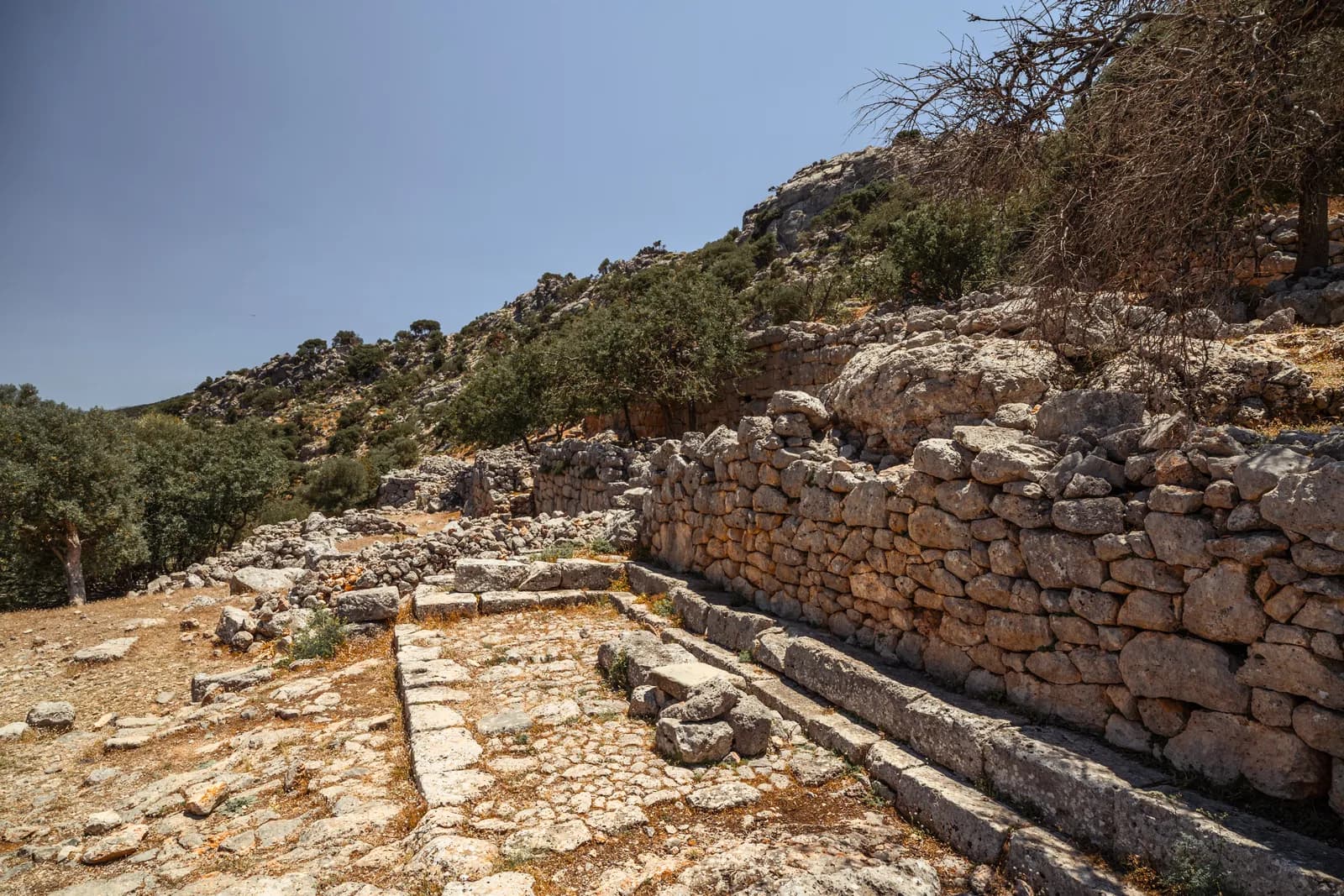 Murs de pierres appareillées et dallage antique sur le site de Lato, à flanc de colline
