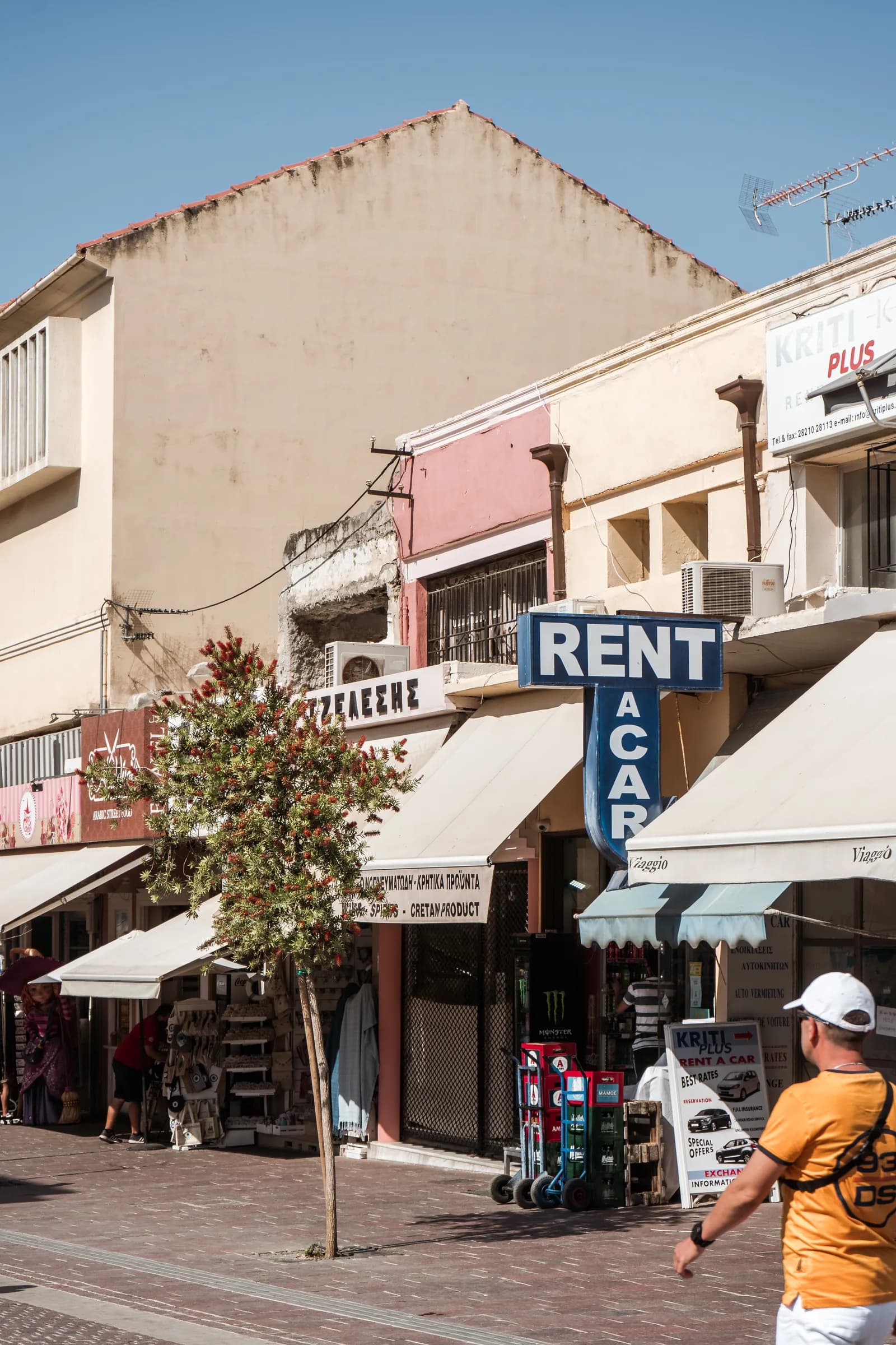 Enseigne d'une agence de location de voitures dans une rue commerçante de La Canée, en Crète