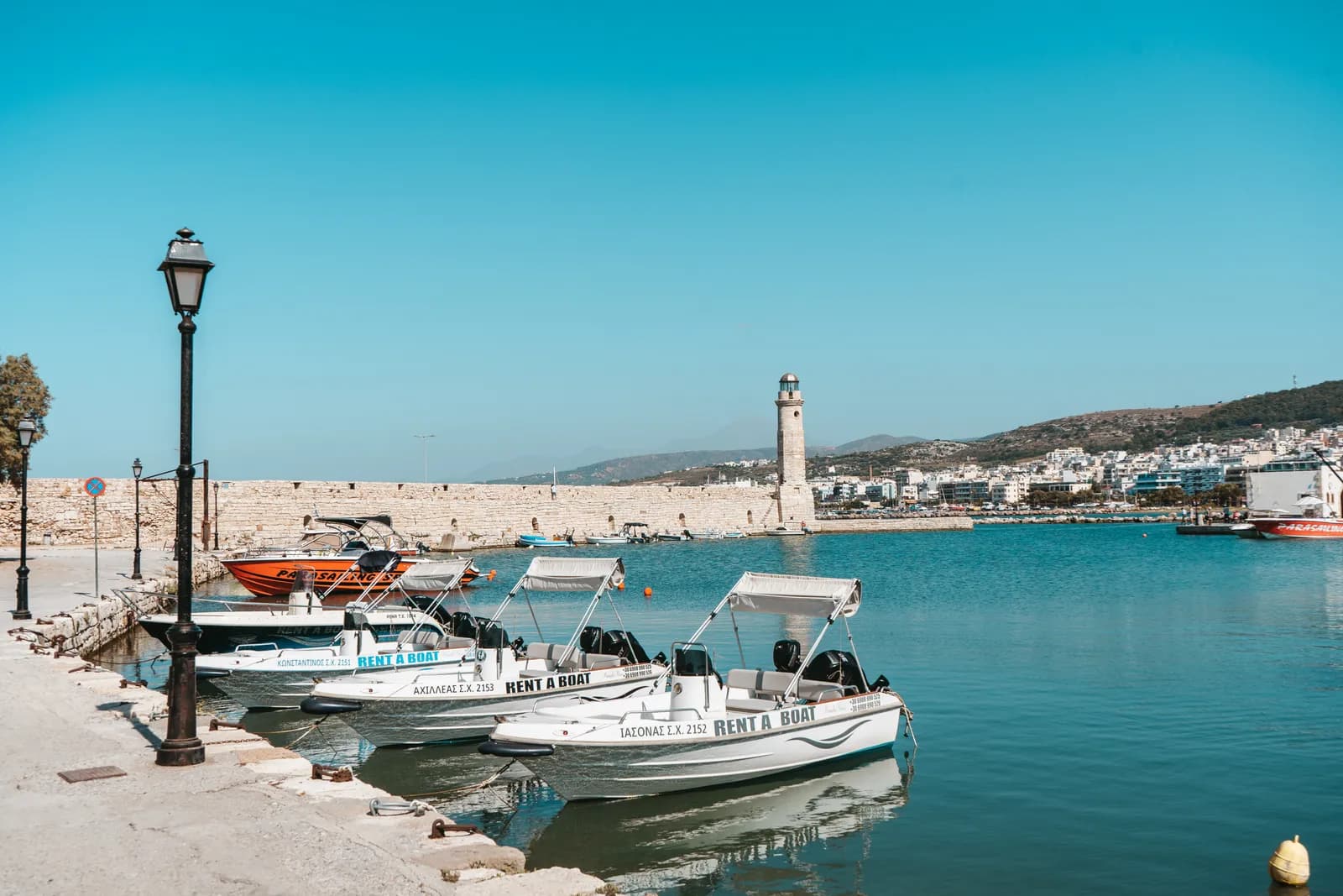 Bateaux de location amarrés dans le port vénitien de Réthymnon, devant le phare au bout de la jetée