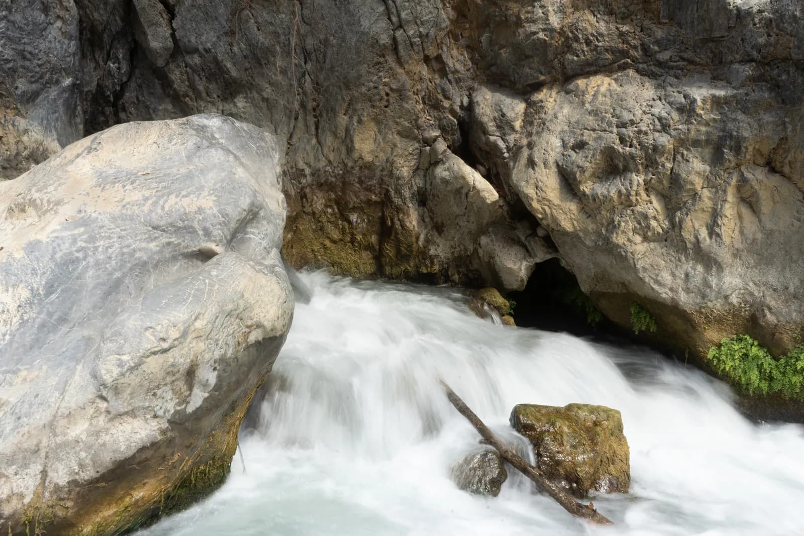 The Megalopotamos river tumbling between large limestone boulders, upstream of the Preveli palm grove