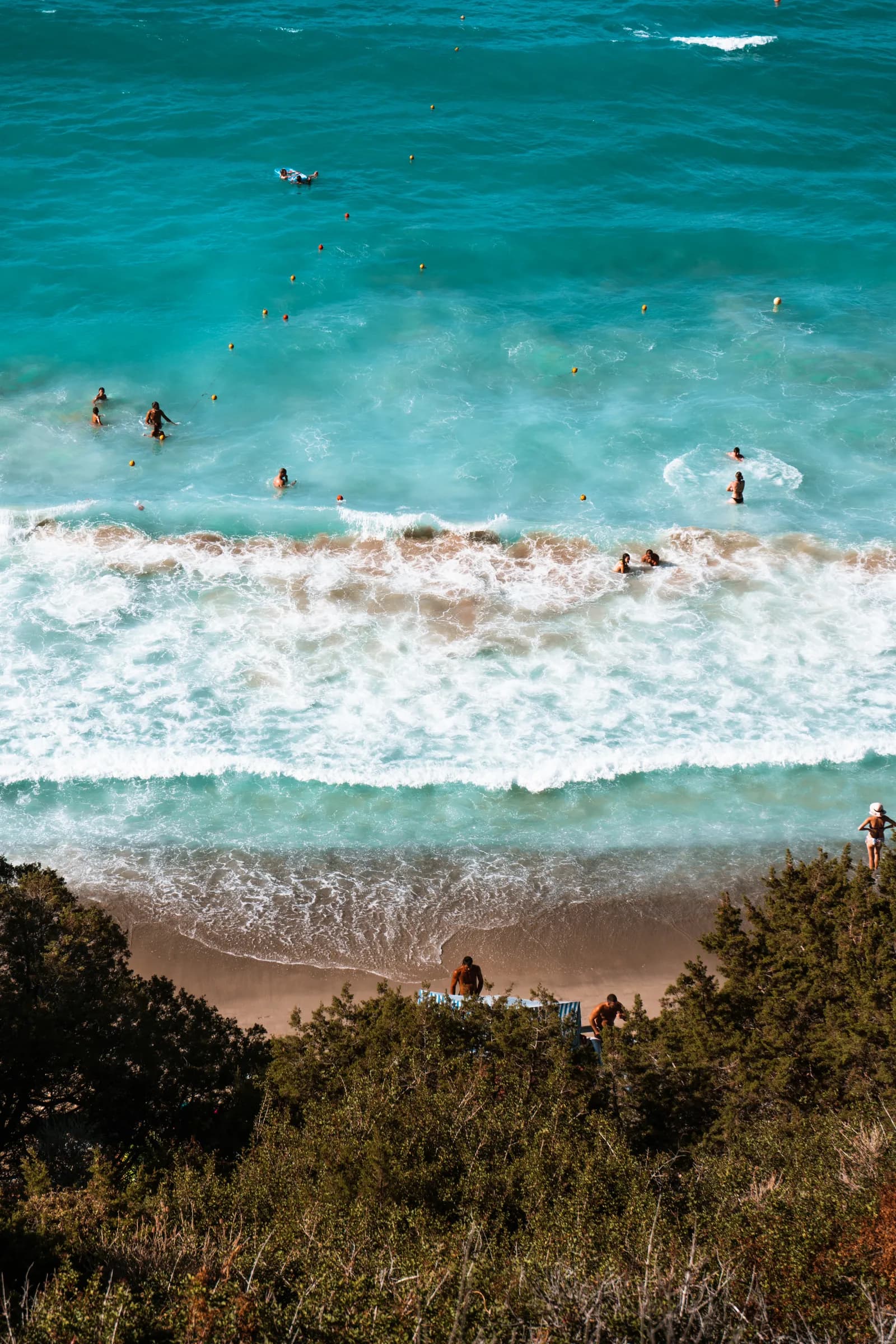 Vagues blanches sur l'eau turquoise et le sable doré de Voulisma, vus d'en haut
